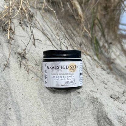 Anti-Aging Balm with Hyaluronic Acid shown with a beach background.