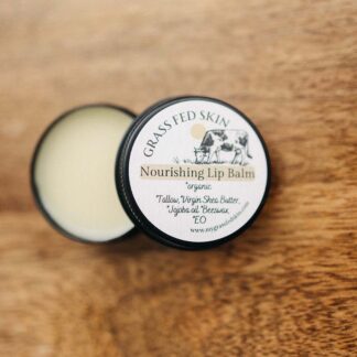 Grass Fed Skin Tallow Lip Balm image on wood table.